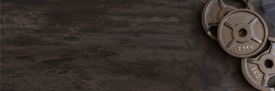 Heavy iron weightlifting plates in 2.5kg, 5kg, and 10kg sizes lined up,  gym ифттук, strength training visuals, personal training advertising, and workout inspiration.