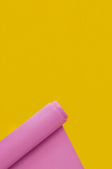 The open yoga mat, on yellow  backgroundfor  yoga practice,  workout, or a healthy routine.