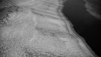 Monochrome aerial landscape showing Queensland ocean waters and intricate natural reef formations