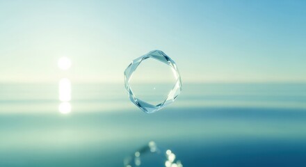 Clear water droplet floating above serene ocean surface at sunrise