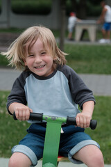 Radosne dziecko bawiące się na placu zabaw © Przemysaw