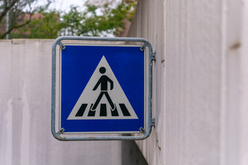 Crosswalk sign guiding pedestrians safely through a busy urban street during bright daylight hours