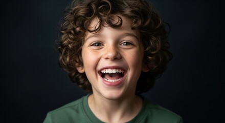 Smiling boy with curly hair enjoying a joyful moment in front of a dark background