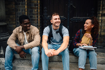 Cheerful students relaxing and talking on university steps