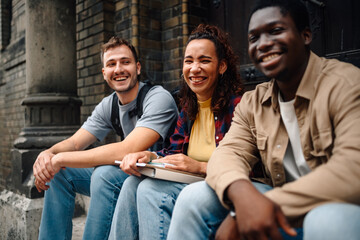 Happy students smiling and relaxing outside university building