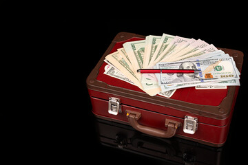 D&oacute;lares americanos sobre maleta.