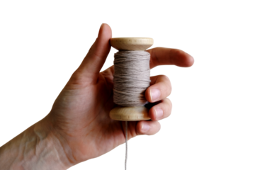 hand holding a spool of thread . Isolated on transparent background, png