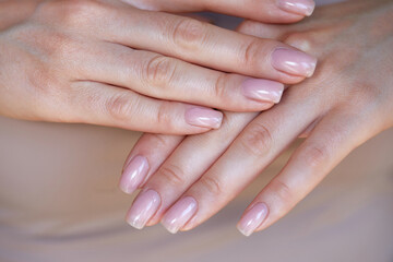 Elegant hands with well-groomed, shiny nails showcase a modern m