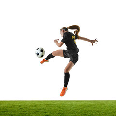 Naklejka premium Female football player in powerful mid-air strike with focused intensity. Concept of peak action, sports ads, agility programs, fitness promotion, match visuals.