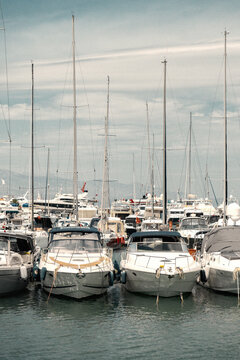 Row of yachts in a busy marina under a clear sky