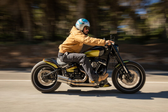 Man riding custom motorcycle on open road