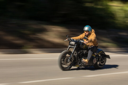Man riding custom motorcycle on a scenic road