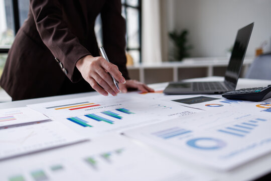 Hand og Many charts and graphs. Reflection light and flare. Concept image of data gathering and statistical working.
 - Powered by Adobe