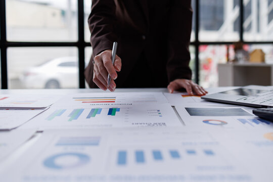 Hand og Many charts and graphs. Reflection light and flare. Concept image of data gathering and statistical working.
