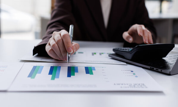 Professional calculator to check analyzing financial data graphs, charts on laptop display at a modern workspace. Financial analysis or business evaluation concept
 - Powered by Adobe