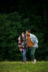 Fototapeta premium Young couple embracing walking in nature together