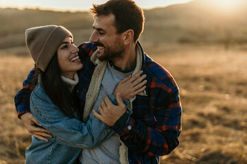 Happy couple embracing outdoors during golden hour sunset