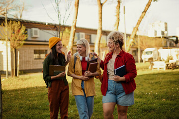 Three female university students walking and talking on campus