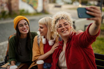 Young women taking selfie enjoying urban friendship