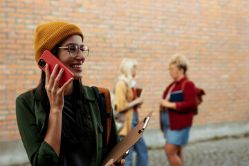 Female student talking on phone smiling outdoors