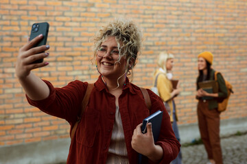 Student taking selfie on campus with friends