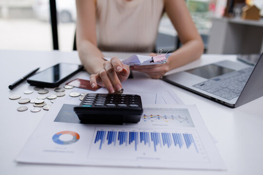 Business woman  hand freelancer managing finances and calculating costs at home office, working remotely.Technology of financial Bill pay concept.
