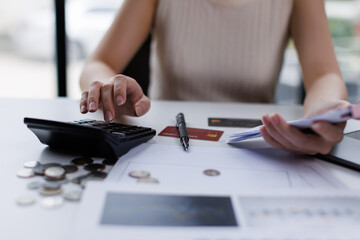 Stressed business woman, employee using calculator to calculate expenses of monthly, hand holding bills and receipt for to payment on table at home. Financial, finance of banking concept

