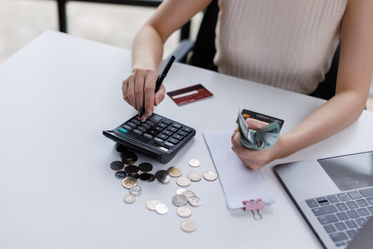 Close up of business woman is calculating for payment finances and holding dollar  managing domestic budget and calculating taxes using calculator and laptop 
 - Powered by Adobe