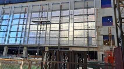 construction site facade with metal cladding installation and scaffolding structure
