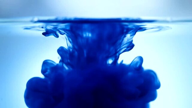 Blue dye drop in transparent water, a captivating slow motion visual of color dissolution and