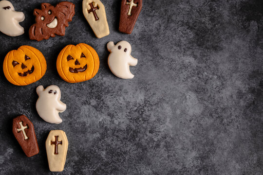 Halloween-themed cookies on dark textured background