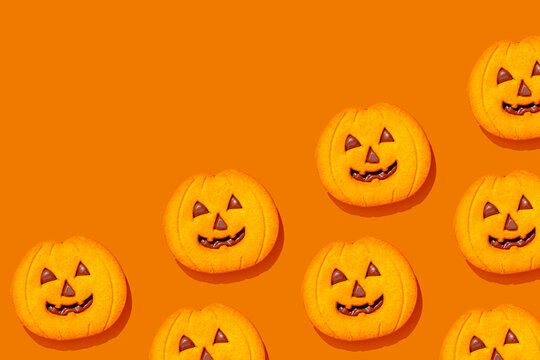 Pumpkin-shaped Halloween cookies on orange background