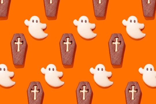 Halloween ghost and coffin cookies on orange background