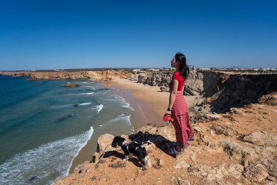 Woman and dog enjoying the view at Praia do Tonel