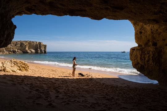 Woman relaxing with her dog at Praia da Coelha beach