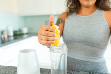 Healthy home juice preparation by unrecognizable woman