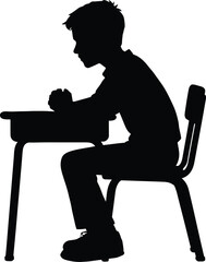 A silhouette of a young boy seated at a desk studying intently