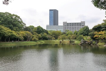 小石川後楽園。水戸徳川家の上屋敷の回遊式築山泉水庭園。琵琶湖を模した大泉水 。その向こうに高層ビル。	
