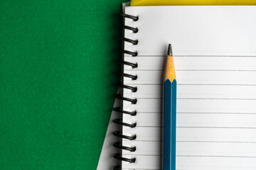 Blank notebook and a calendar Working table with keyboard and notepad, pen, pencil and plant in home office. top view 