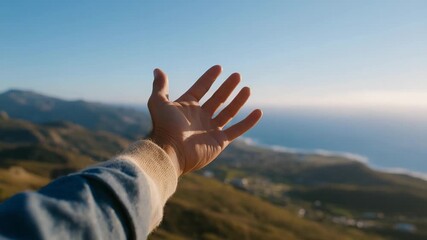 Arm reaching up toward a clear blue sky from scenic hilltop or open field — concept of freedom, hope, aspiration, personal growth, and inspirational outdoor lifestyle photography. cinematic color