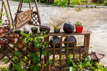 Garden landscape with a fence decorated with small pots and flower pots