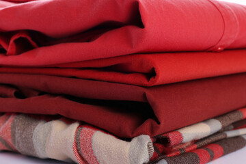 Stack of folded clean clothes on white background, closeup