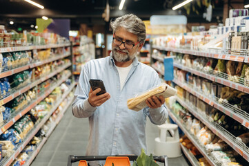 Choosing spaghetti, pasta. A senior man is buying food in the grocery store