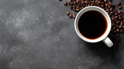 Top view of black coffee in a white glass cup placed on a rustic cement table with scattered coffee beans, illustrating morning coffee ritual, beverage enjoyment, aroma, and cozy cafe atmosphere