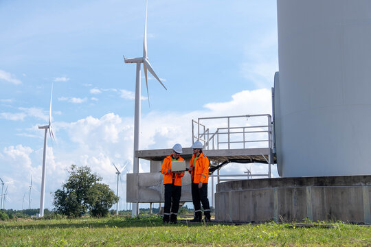 Team conducts maintenance check near wind turbines on a sunny day in a renewable energy field