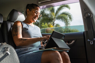 Businesswoman working in car with a tablet
