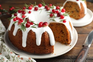 Tasty Christmas cake with cranberries and knife on wooden table, closeup