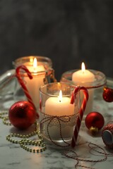 Beautiful Christmas lanterns and festive decor on white marble table, closeup