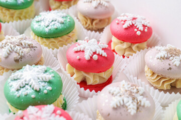 Festively decorated macarons in box, closeup. Christmas treat