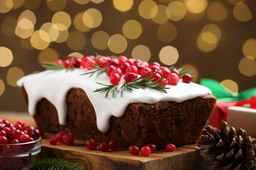 Tasty Christmas cake with cranberries and rosemary on table, closeup. Bokeh effect